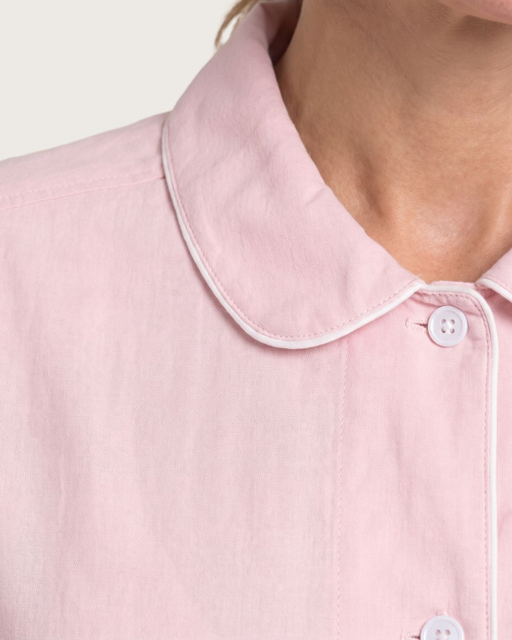 Close-up of rounded collar, white piping and button on Amber pink pajama top