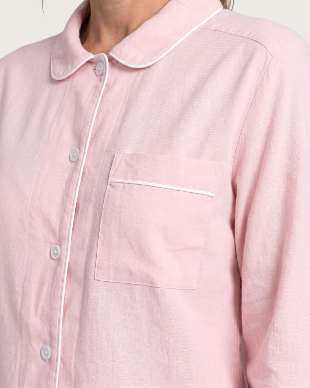 Close-up of chest pocket, buttons and white piping on Amber pink pajama top