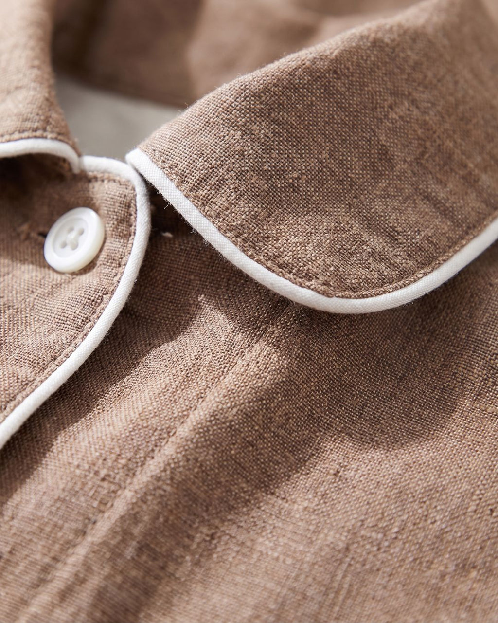 Close-up of rounded collar and white piping on Hazel brown cotton pajama top