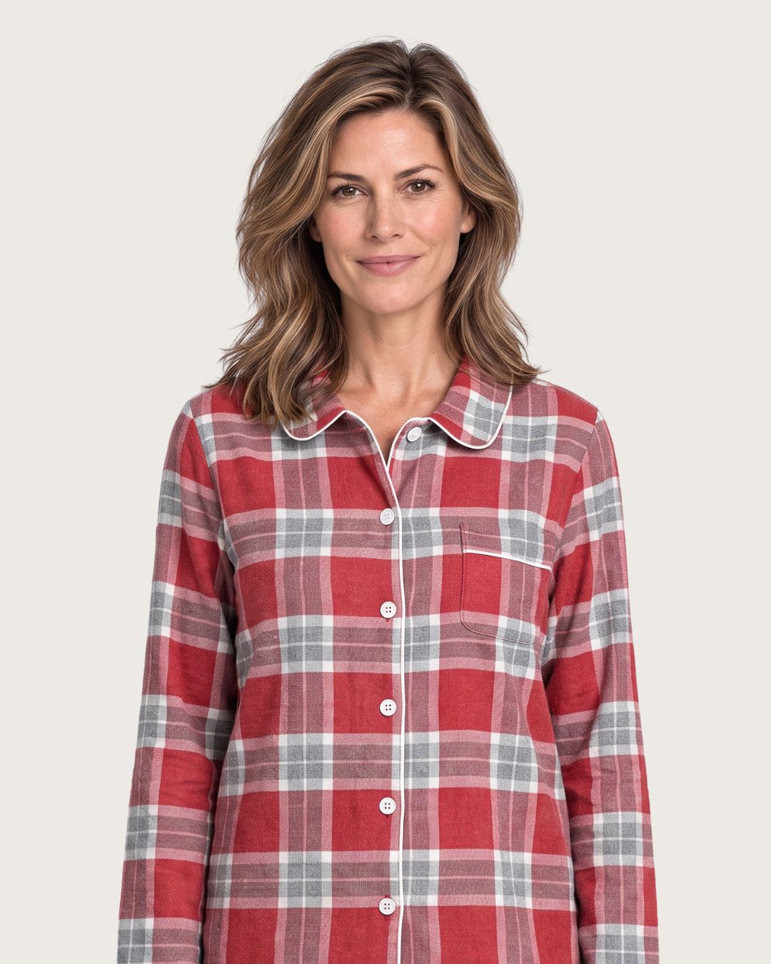 Woman wearing Rowan red plaid cotton flannel pajamas, upper-body studio view