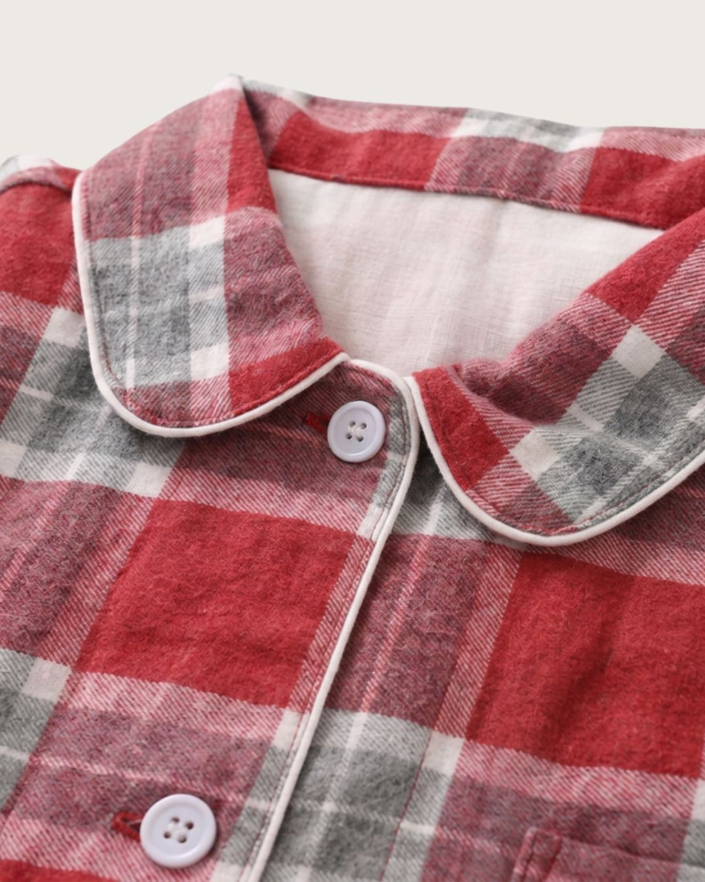 Detailed view of Rowan red plaid flannel pajama collar, buttons and piping